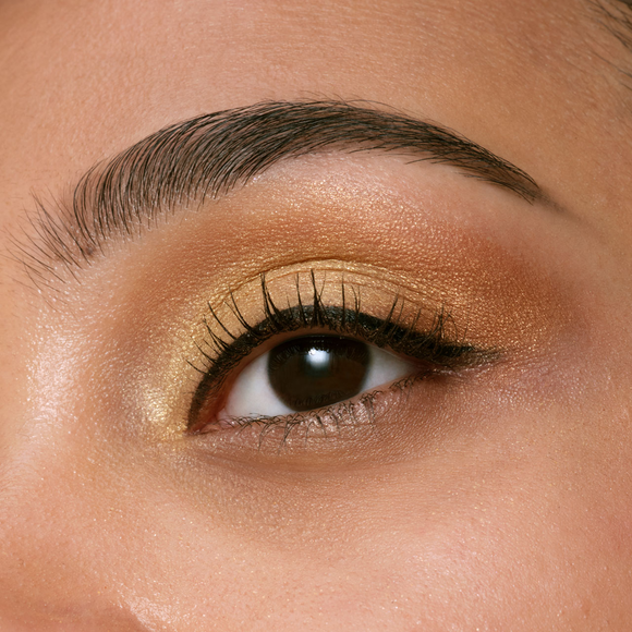 Photo of the 26 AW Holiday Collection limited-edition EYE COLOR QUAD on a dark-skinned model. A close-up shot focuses on her eye, displaying the applied eyeshadow gradient on her eyelid and upper brow bone area.