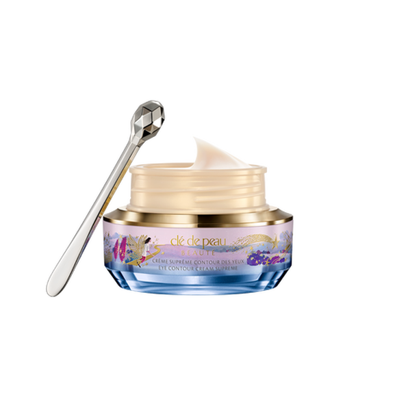 Photo of the 26 AW Holiday Collection limited-edition EYE CONTOUR CREAM SUPREME. The jar is open,revealing the smooth pale cream inside, alongside a faceted silver spatula.