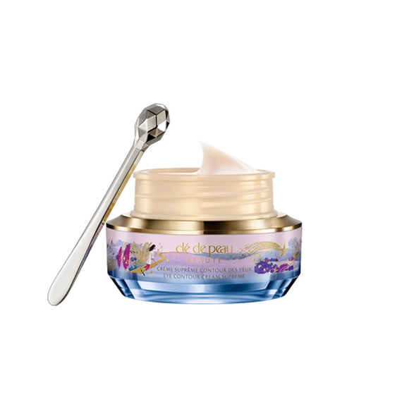 Photo of the 26 AW Holiday Collection limited-edition EYE CONTOUR CREAM SUPREME. The jar is open,revealing the smooth pale cream inside, alongside a faceted silver spatula.
