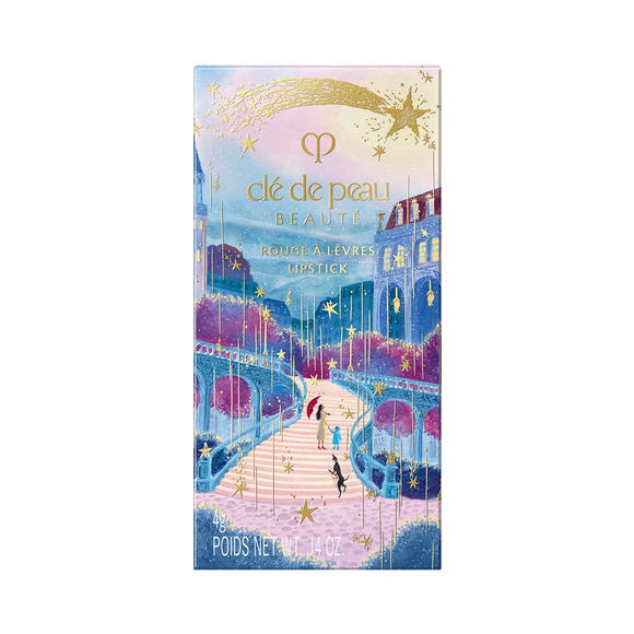 Photo of the 26 AW Holiday Collection limited-edition LIPSTICK outer box. The rectangular package features a scenic illustration of figures on a path under a starry sky with a castle, decorated with a large gold shooting star across the top.