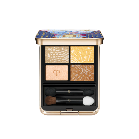 Photo of the 26 AW Holiday Collection limited-edition EYE COLOR QUAD. The opened gold compact reveals a four-shade eyeshadow palette and two applicators below. Three shades feature engraved star patterns, while one shade is embossed with the brand logo.